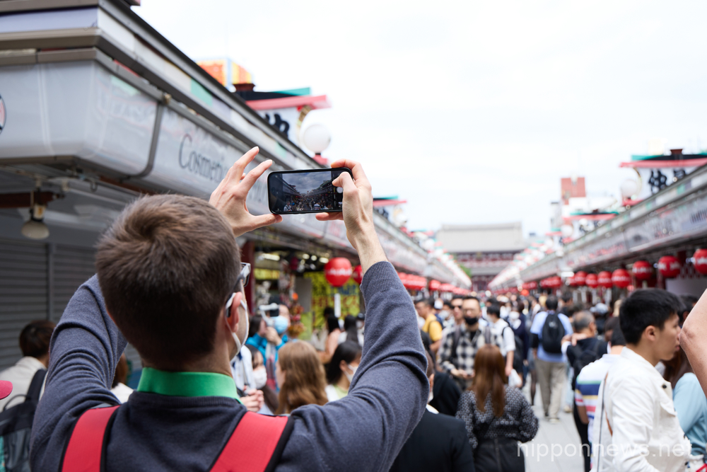 A foreign tourist takes picture at Nakamise shopping street, an approach to the Sensoji temple in Asakusa entertainment district, Tokyo in Japan on May 1, 2023. (Yohei Osada/AFLO)