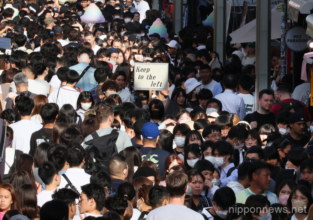 May 5, 2023, Tokyo, Japan - A police officer raises a placard "Keep left to the left" as the Takeshita street is crowded with people at the Harajuku fashion district in Tokyo at a week-long Golden Week holidays on Friday, May 5, 2023. (photo by Yoshio Tsunoda/AFLO)